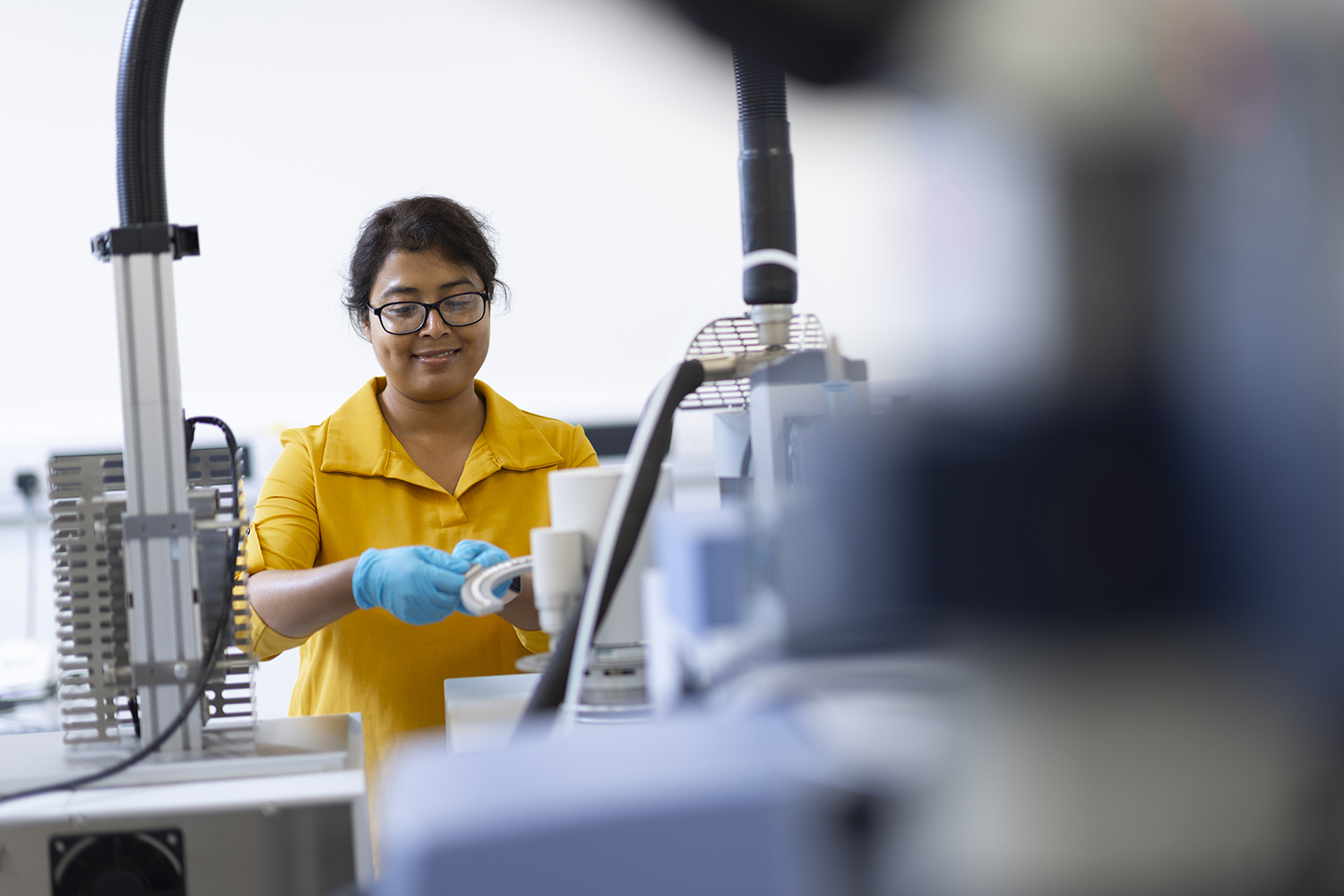 A woman wearing yellow loading samples onto an STA