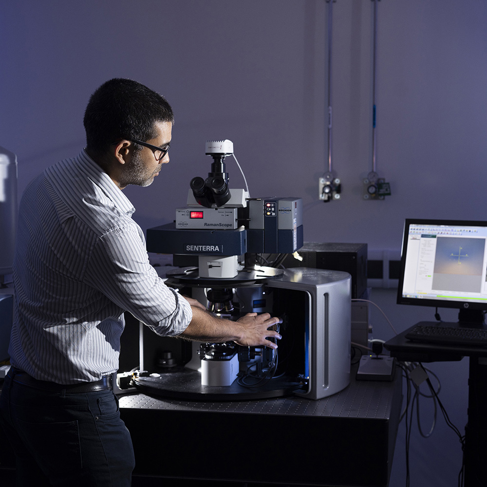 A man loading a sample into a Raman.