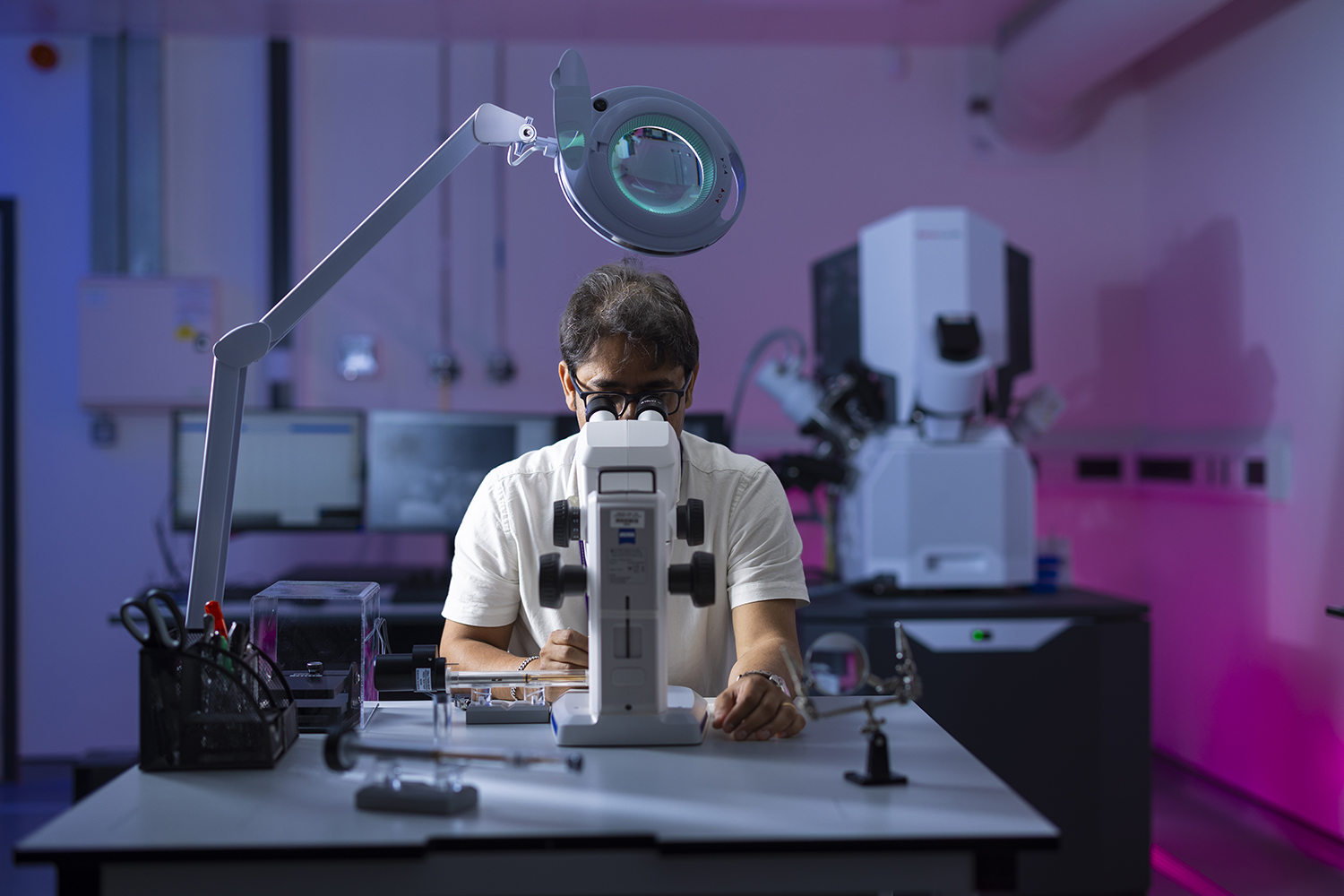 Man looking at microscope in a laboratory