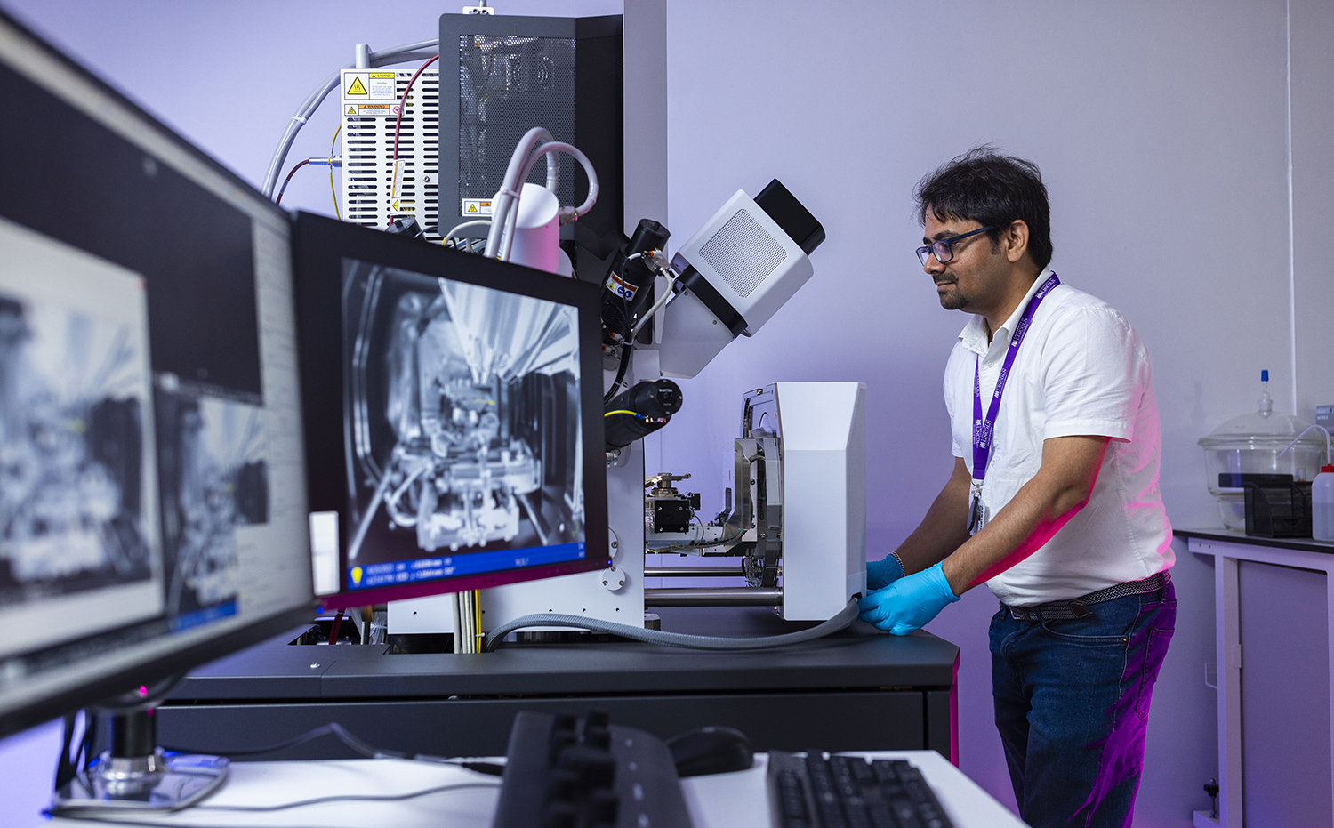 A man loading a sample into a FIB-SEM