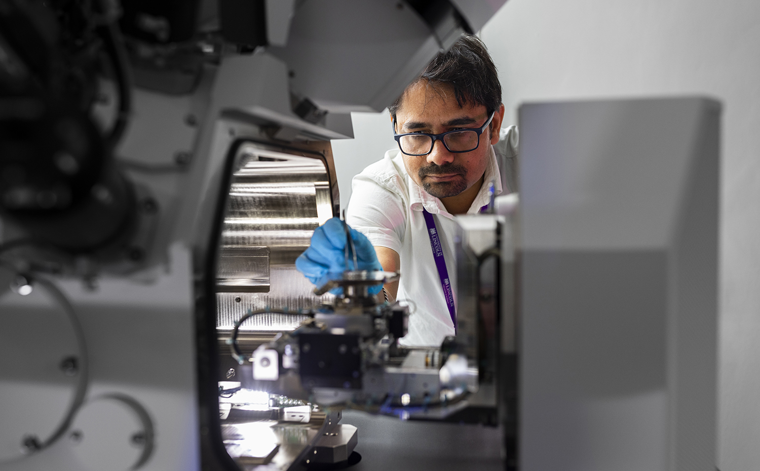 A man looking at a sample inside a FIB-SEM