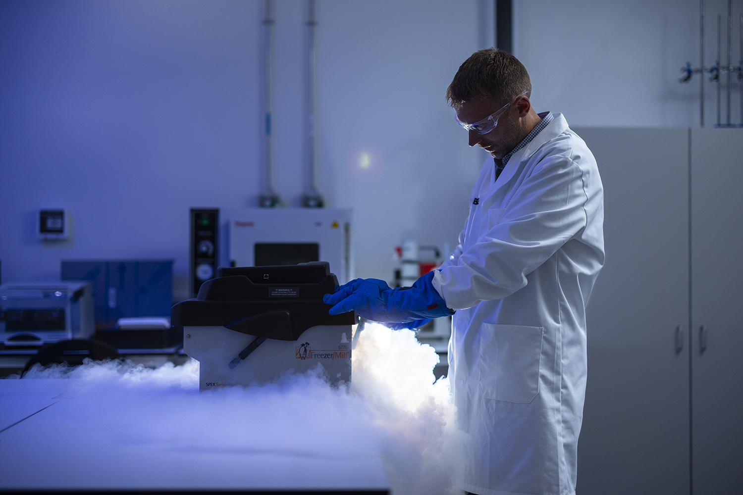 Man pouring liquid nitrogen into a device in a laboratory
