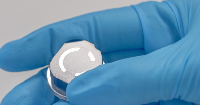 image of a metal sample in a gloved hand